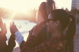 Friends sharing a happy moment during travel at sunset, emphasizing friendship and adventure. 