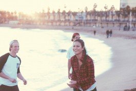 Beach walk with friends during sunset, smiling and having fun by the ocean. 