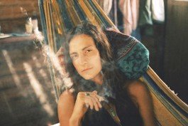 Robin Mellor - Relaxed woman lying in a hammock, enjoying a peaceful moment outdoors with natural sunlight. 