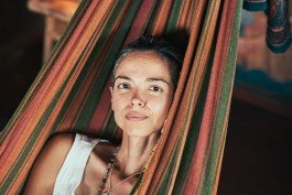 Robin Mellor - Relaxed woman resting in colorful hammock, enjoying outdoor leisure and relaxation. 