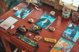 Robin Mellor - Intricate tarot cards and crystals arranged on a wooden table for spiritual guidance and meditation. 