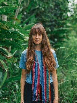 Robin Mellor in lush green garden surrounded by tropical plants. 