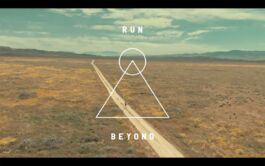 Desert plain with a long dirt road, overlaid by a white circle and triangle, with RUN at the top and BEYOND at the bottom. 